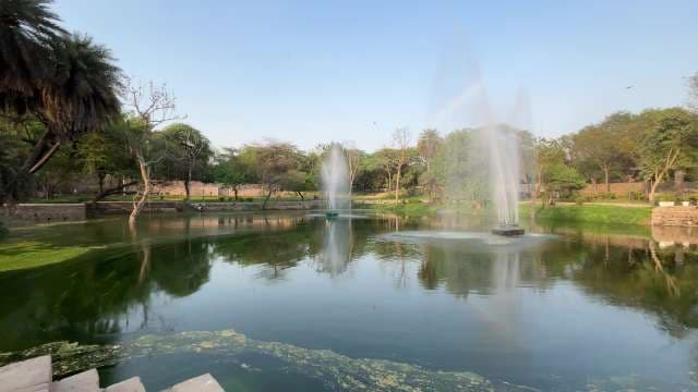 Peaceful Garden Lake with Fountains in Lush Green Park