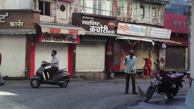 Street Sweeper at Work in Busy Indore Market Street