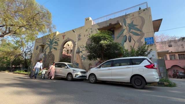 Family Strolling in Urban Neighborhood With Colorful Wall Art