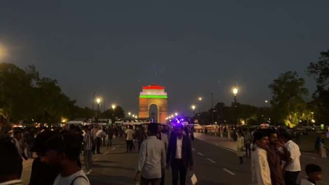 India Gate Illuminated at Night with Vibrant City Crowd