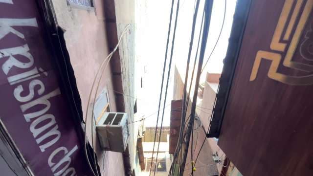 Narrow Urban Alleyway With Hanging Cables in Daylight