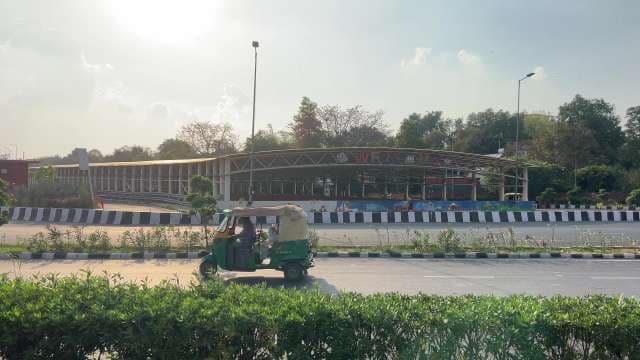 Auto Rickshaw Passing Delhi Welcome Center in Afternoon Sun