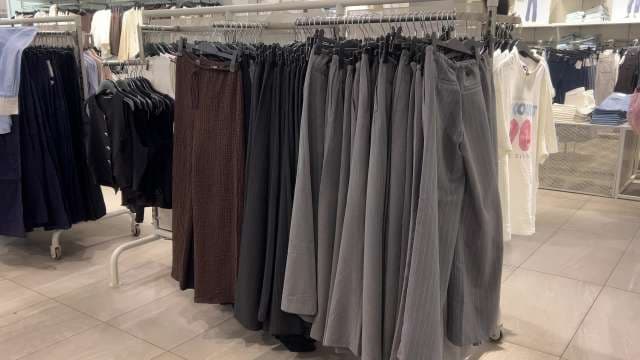 Trendy Wide-Leg Pants and Skirts on Clothing Rack Display