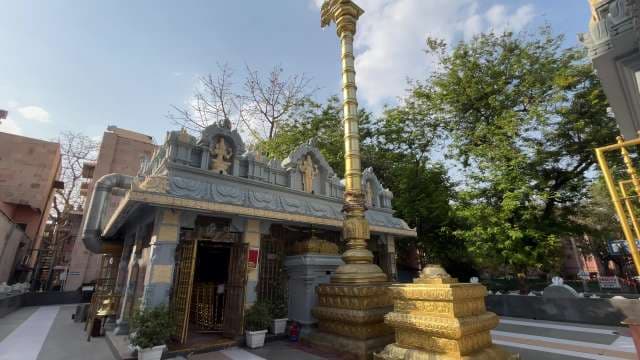 Beautiful Hindu Temple With Ornate Gold Pillar in Urban Setting