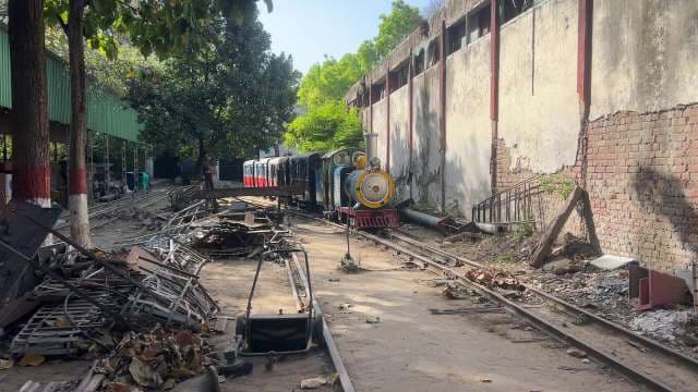 Colorful Miniature Train Passing Through Urban Railway Yard
