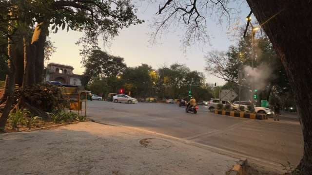 Busy Evening at Delhi City Intersection With Traffic and Trees