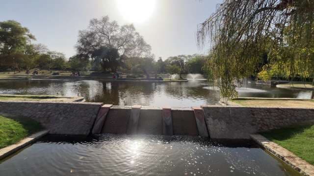 Tranquil Park Pond With Fountains and Stone Dam