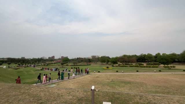 People Enjoying a Scenic Park Walk on a Cloudy Day