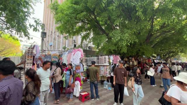 Bustling Street Market with Clothing and Accessories Stalls