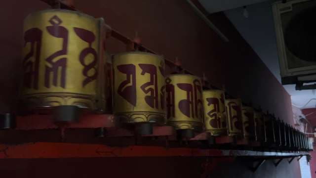 Spinning Tibetan Prayer Wheels in Monastery Corridor