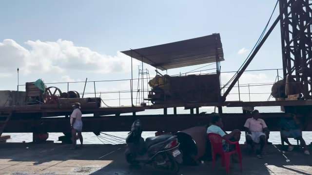 Workers and Machinery on Coastal Industrial Waterfront