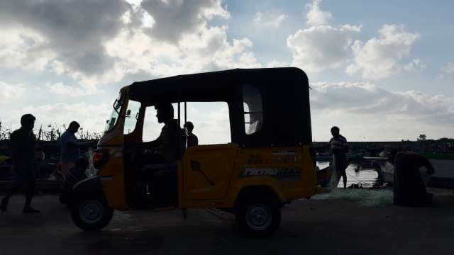 Silhouette of Auto Rickshaw and Fishermen at Chennai Harbor