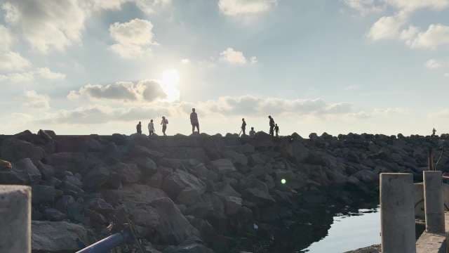 People Walking on Rocky Breakwater at Sunset in a beach in Chennai 