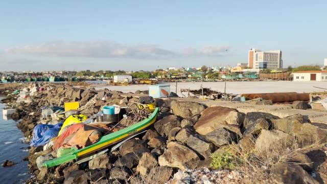 Colorful Fishing Boats and Rocky Shore in Coastal City Harbor