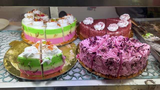 Colorful Assorted Cakes on Display in Bakery Showcase