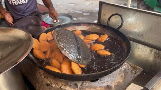 Street Vendor Frying Fresh Indian Snacks in Large Kadai
