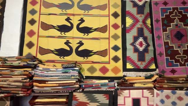 Colorful Handwoven Traditional Rugs Displayed in Market Stall