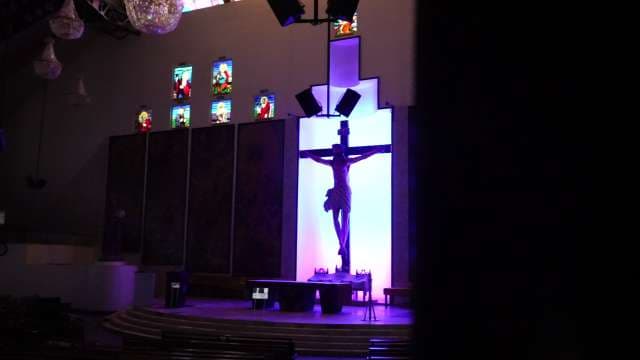 Modern Church Interior With Illuminated Crucifix and Stained Glass