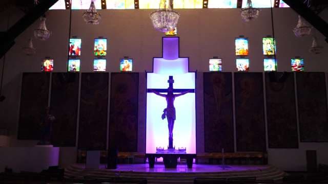 Modern Church Interior With Illuminated Crucifix and Stained Glass