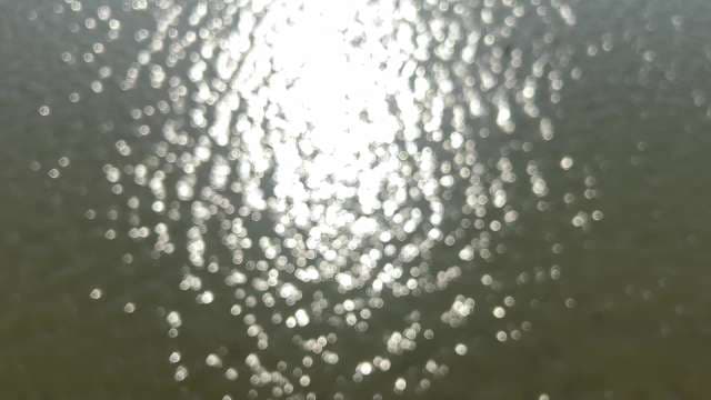 Sun Glitter Sparkles on Rippling Water Surface