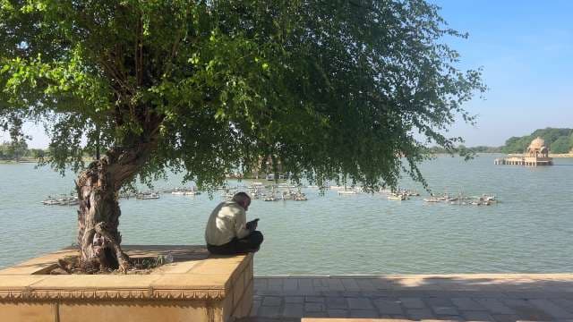 Man Relaxing Under Shade Tree by Gadisar Lake