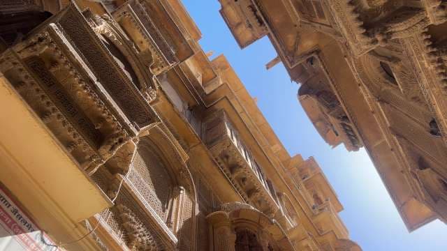 Intricate Facades of Jaisalmer's Historic Havelis Under Blue Sky