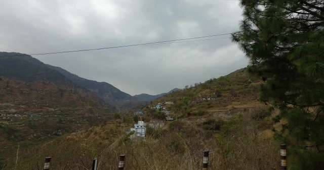 Serene Mountain Village Among Lush Hills Under Cloudy Skies