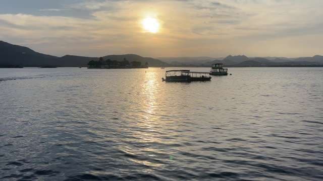 Serene Sunset Over Lake Pichola With Boats and Mountains