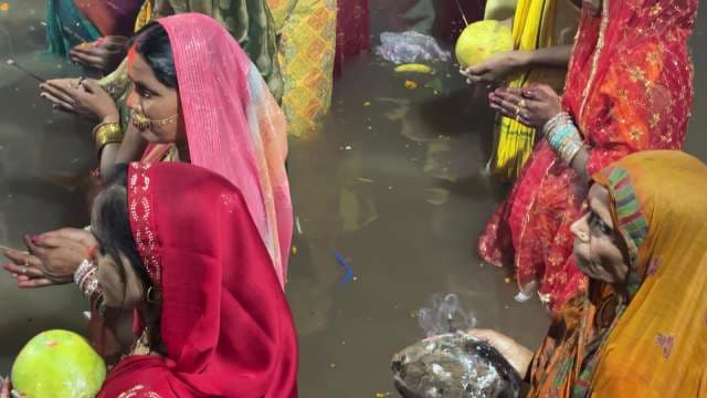 Devotees Perform Chhath Puja Rituals in River at Night
