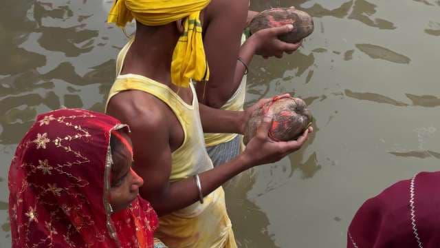Hindu Devotees Perform Ritual with Offerings by River