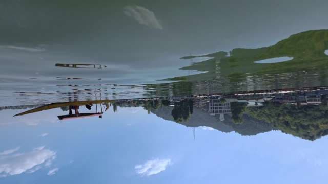 Inverted Waterfront Reflection with Boats and Cliffs