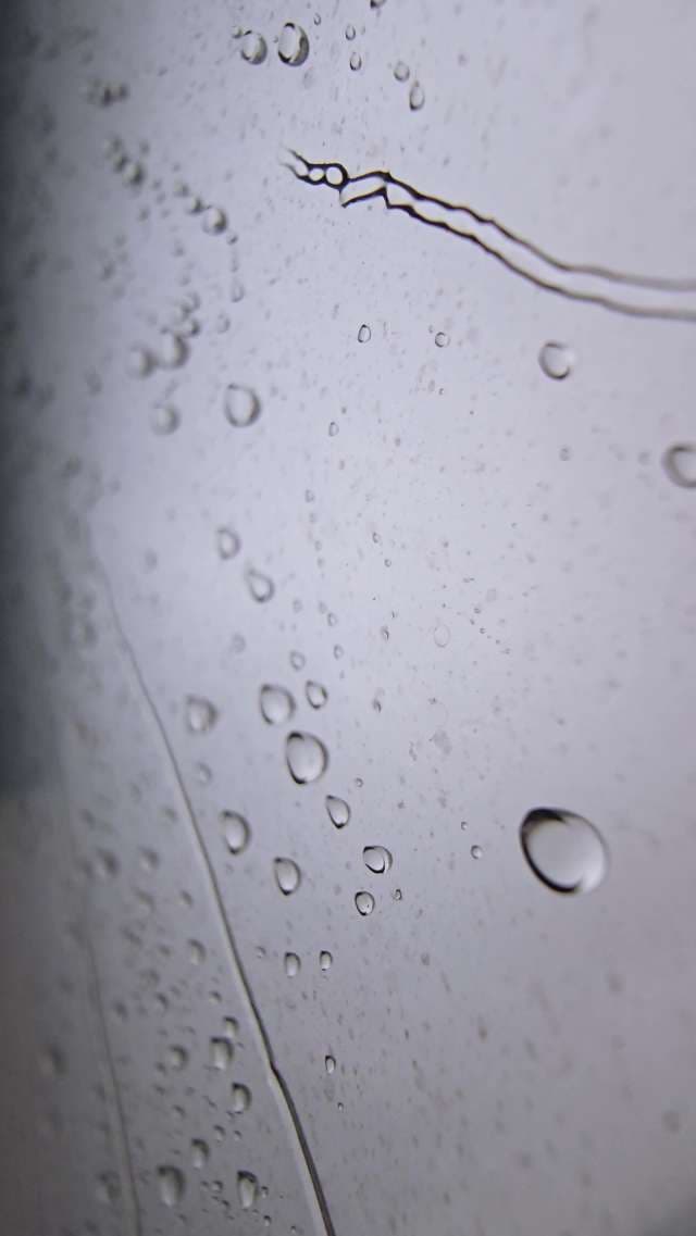 Mesmerizing Raindrops Cascading on Glass
