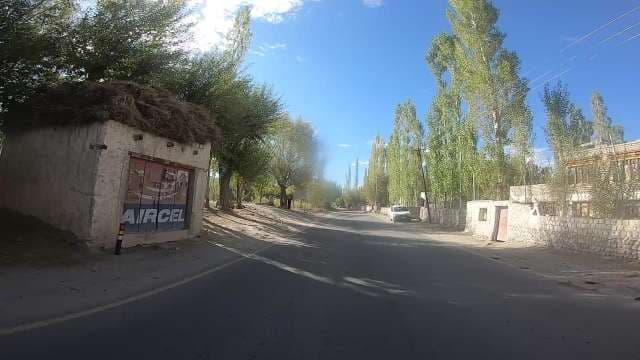 Majestic Ladakh Village Road Amidst Towering Mountains