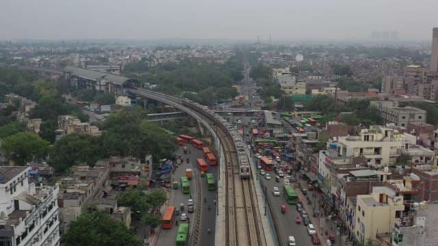 Delhi Metro Elevated Train Through Bustling City Streets