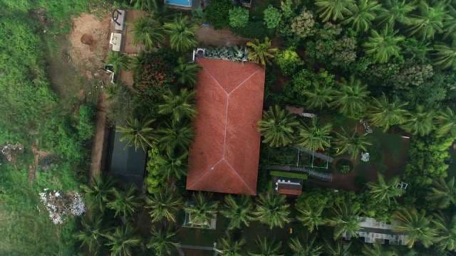 Tropical House Aerial View: Red Roof Surrounded by Lush Jungle