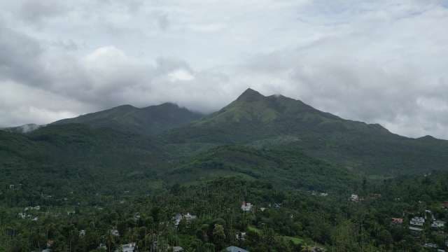 Lush Green Mountains and Valley with Dramatic Cloudy Sky