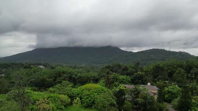 Mountain Landscape: Lush Tropical Peak with Storm Clouds
