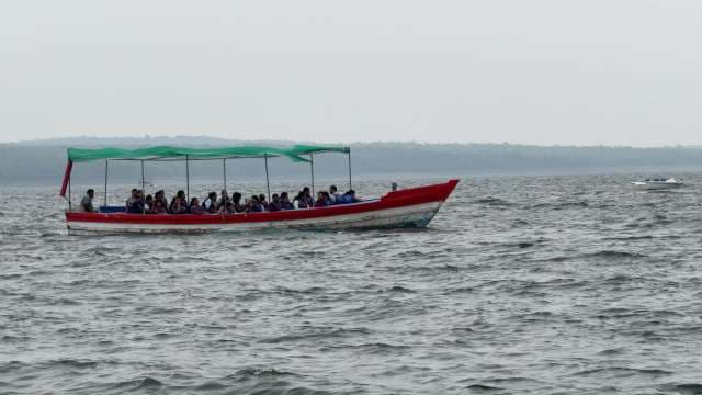 Red and Green Boat: Crowded Passenger Transport on Ocean