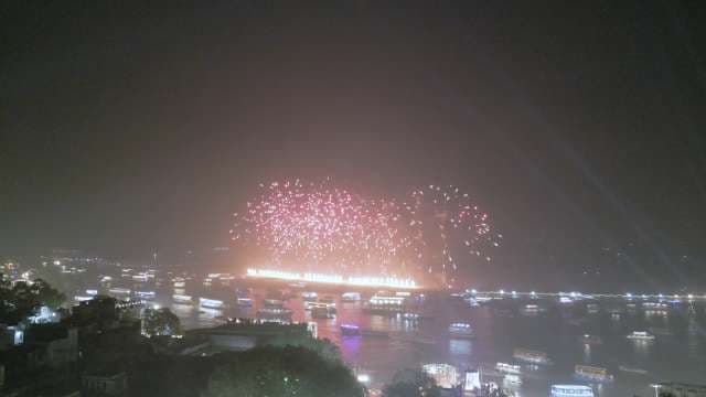 Spectacular Fireworks Display Over River City at Night