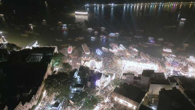 Vibrant Night Festival Celebration by River with Illuminated Boats