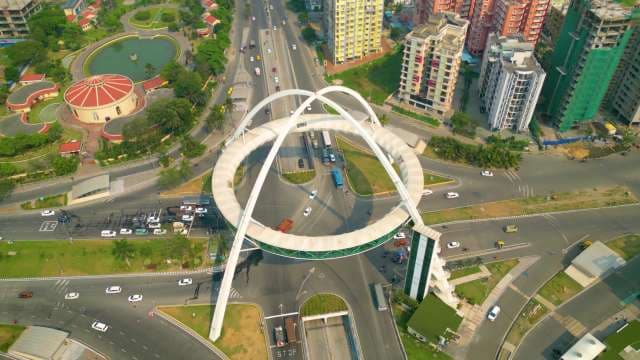 Modern Arch Bridge Over Urban Highway and City Skyline
