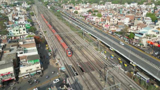 High-Speed Vande Bharat Train Traveling Through Urban Indian Cityscape