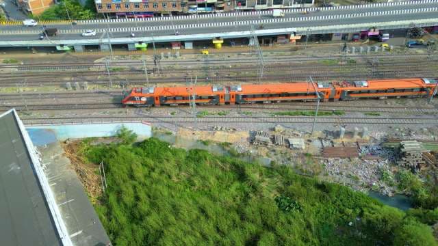High-Speed Vande Bharat Express Train Traveling Through Urban Cityscape