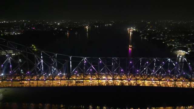 Iconic Howrah Bridge Glowing at Night with Busy Traffic