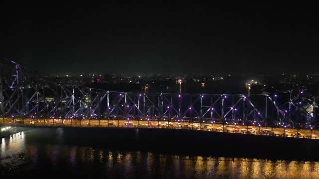 Iconic Howrah Bridge Illuminated Over Hooghly River in Kolkata at Night