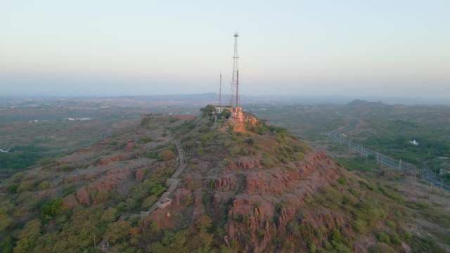 Scenic Drone Shot of a Communication Tower on a Rocky Hill