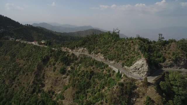 Scenic Winding Mountain Road Through Lush Green Hills and Valleys