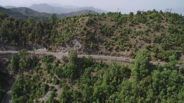 Scenic Aerial View of a Car Navigating a Winding Mountain Road