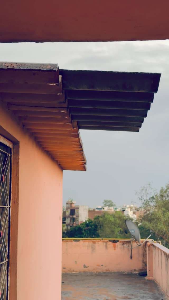 Calm Rain Falling From Rooftop Overhang In Delhi Neighborhood