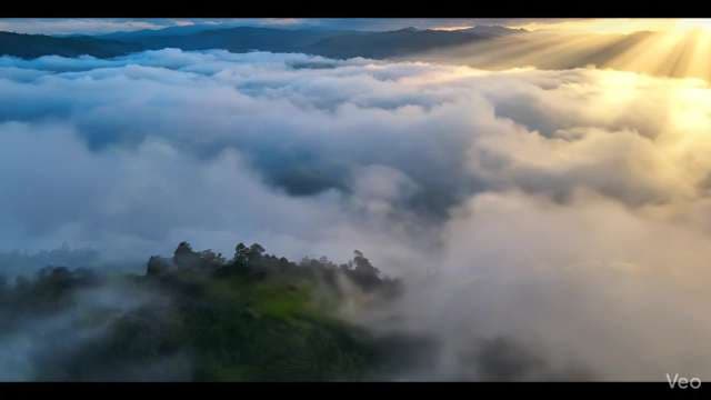 Aerial Sunrise View Over Foggy Mountain Peaks